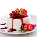 Close up photograph of a tasty panna cotta with red fruits