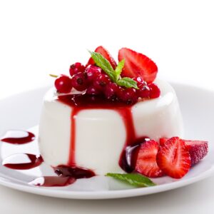 Close up photograph of a tasty panna cotta with red fruits